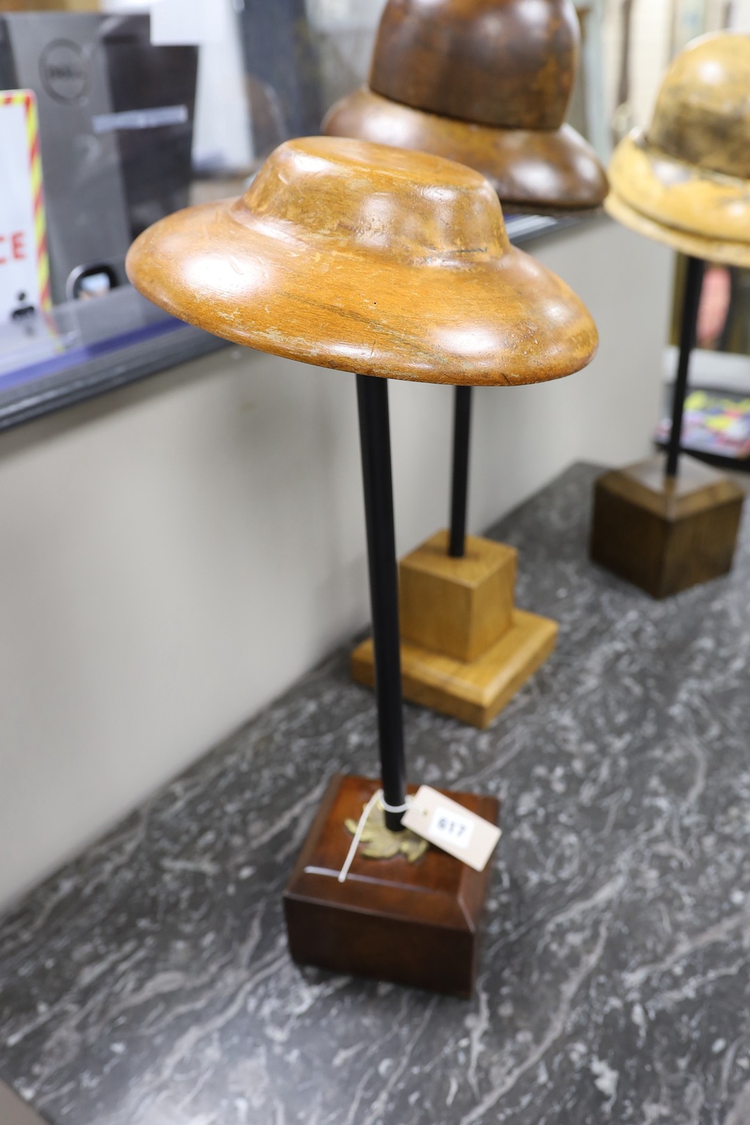 A group of three vintage milliner's hat-blocks, on stands